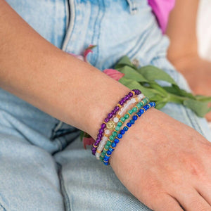 Four fine Soultheory Luck crystal bracelets worn together on a wrist, with Soultheory charm