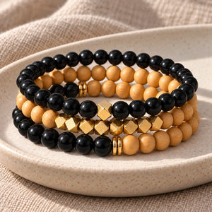 Three Black Onyx and Rosewood bead bracelets stacked on an ivory tray