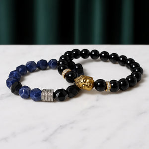 Black Buddha bead bracelet with faceted lapis lazuli and obsidian bracelet arranged on marble