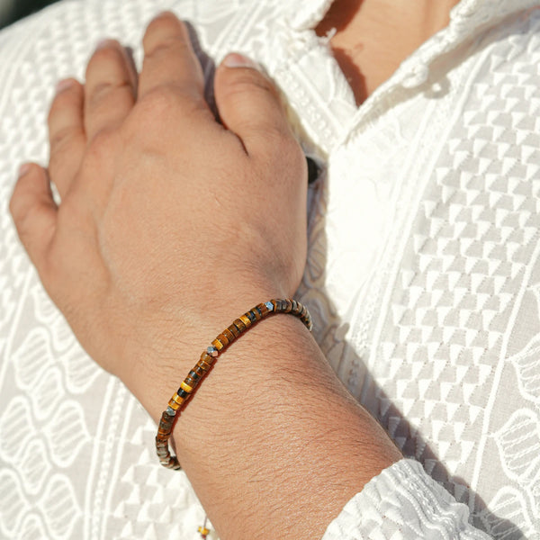 Tiger eye bracelet worn on a man's wrist in sunlight, slim heishi beads for confidence and energy