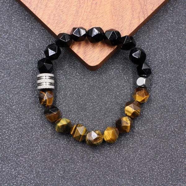 Tiger eye and obsidian bracelet flat lay with wood prop showing tiger eye stripes and glossy obsidian