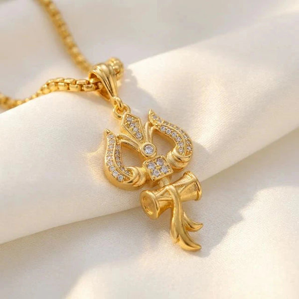 Close-up of golden trishul om and damru pendant with tiny crystal accents on ivory satin