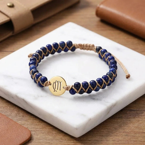 Lapis lazuli Virgo zodiac bracelet flat lay on white marble with gold sign charm and woven cord