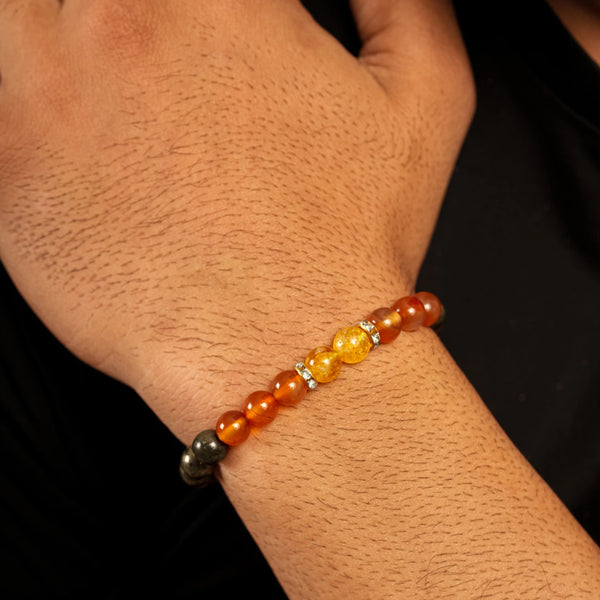 Close-up of wealth bracelet on wrist showing orange carnelian and yellow citrine beads