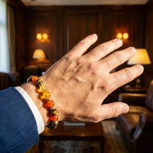 Man wearing wealth stone bracelet in a study, tiger eye and carnelian beads on wrist